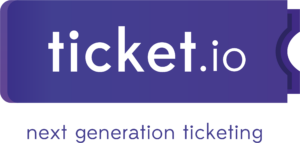 Logo von der Online-Plattform für Ticket-Verkäufe „ticket.io“. Zu sehen ist ein dunkelblaues Rechteck, welches zur rechten Seite zu Wellen zusammenläuft. Es sieht aus wie ein Ticket, welches von einem anderen Ticket abgerissen wurde. In weißen Buchstaben steht darauf: „ticket.io“. Darunter, auf durchsichtigem Untergrund steht in dunkelblauen Buchstaben „next generation ticketing".