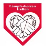 Das Logo des Kämpferherzen treffens: Eine rote Grundfläche in Form einer Flagge: ein Quadrat und daran nach unten hin ein Dreieck. Darin ein weißes Herz, in dem ein weiteres Herz mit geometrischen Linien gezeichnet ist. Dieses geometrische Herz läuft zu seiner Spitze hin ein zwei Hände aus, die in einander greifen, als würden sie sich festhalten. Über dem Herz steht in weißer Schrift "Kämpferherzen Treffen."